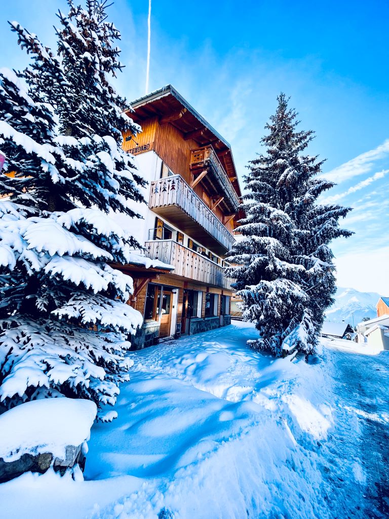 Très belle vue du Chalet enneigé et ensoleillé à Alpe d'Huez - 1850 m, face au parking du coulet