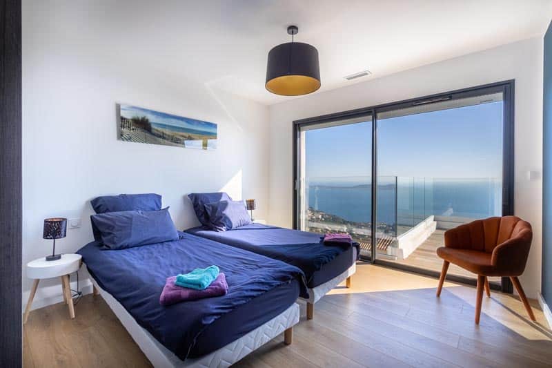 Dormitorio 4 con dos camas individuales y un gran armario, vista al mar desde la villa La Californie