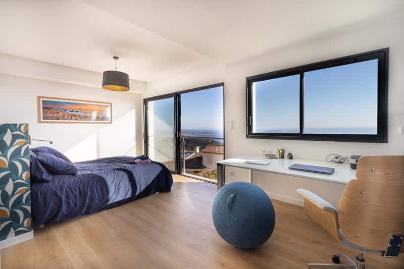 Schlafzimmer 1 mit Bett 160 mit Meerblick und einem Arbeitsbereich der Villa La Californie